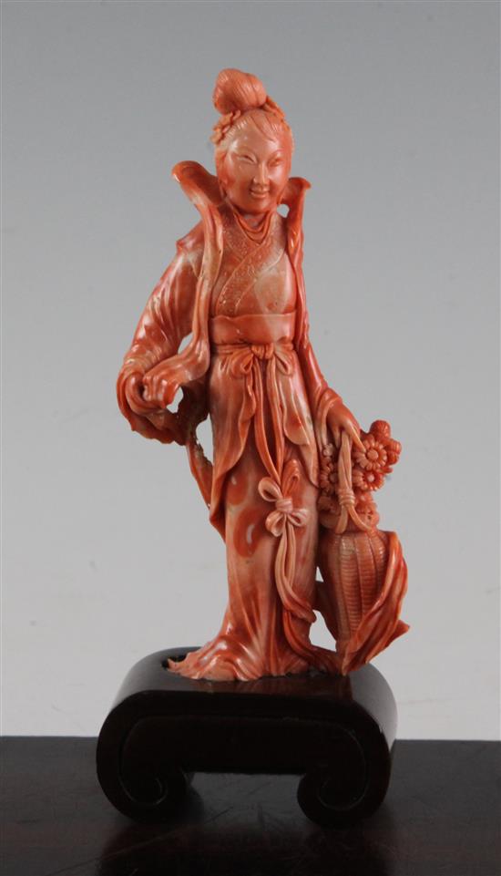 A Chinese coral figure of a beautiful lady holding a basket of flowers, 17.5cm incl. wood stand